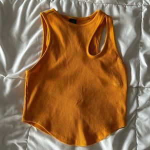 Orange tank top with open slit in the shoulder.